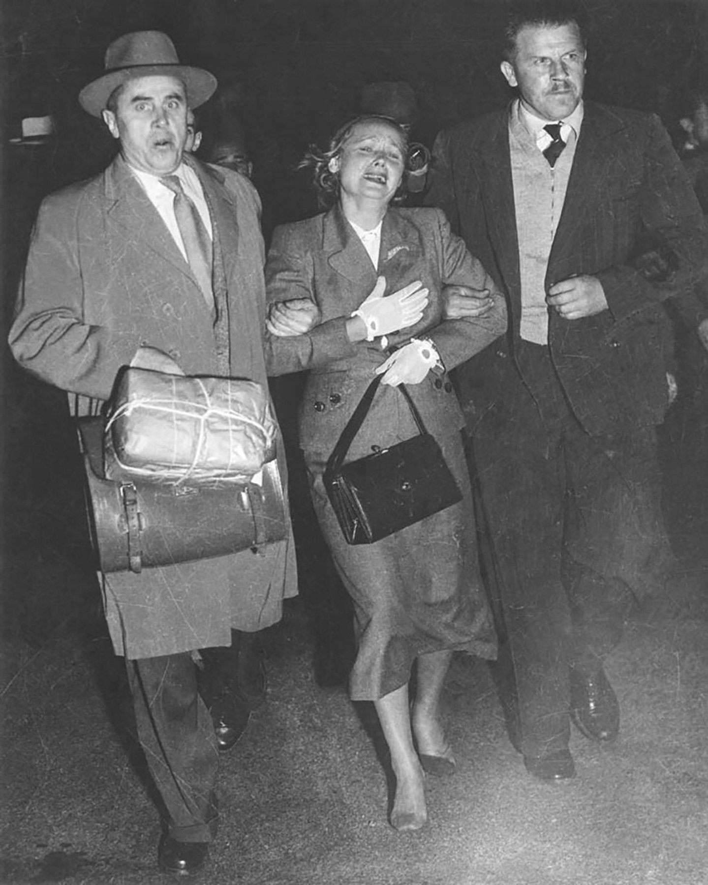 Evdokia Petrov crossing the tarmac at Mascot Airport between Soviet diplomatic couriers