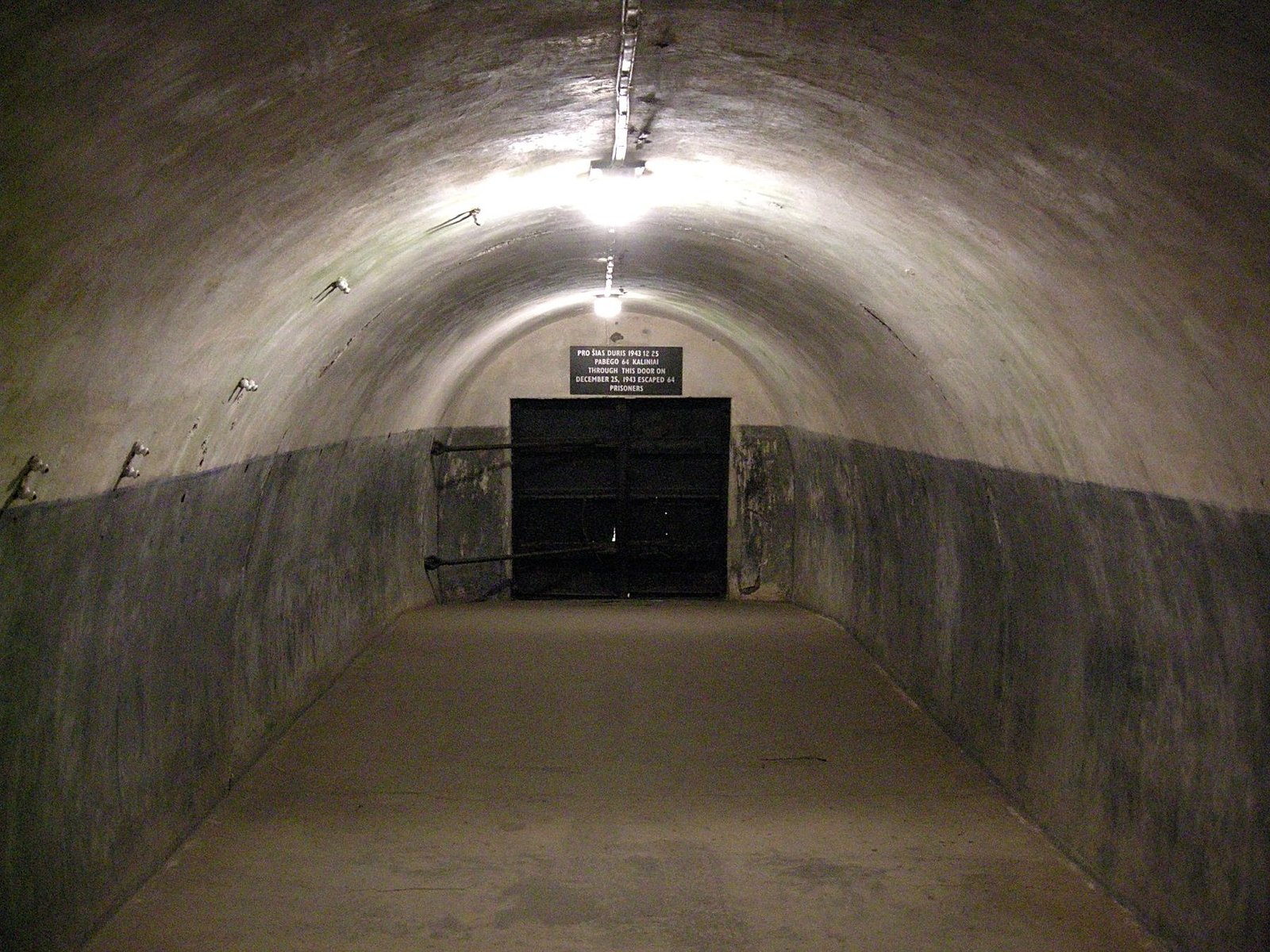 Heavy metal door inside the underground corridors of Kaunas Ninth Fort, identified at the site as the door through which 64 prisoners escaped in December 1943.