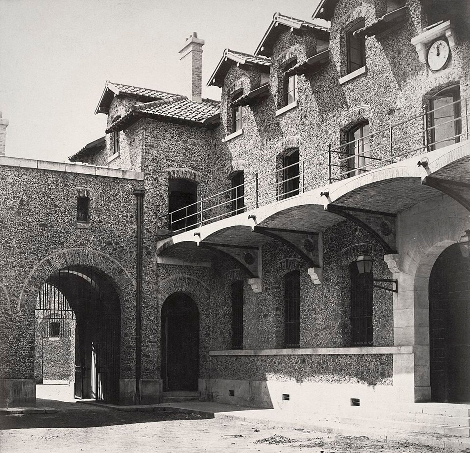 Black-and-white nineteenth-century photograph of an interior courtyard and stone buildings at La Santé prison in Paris.