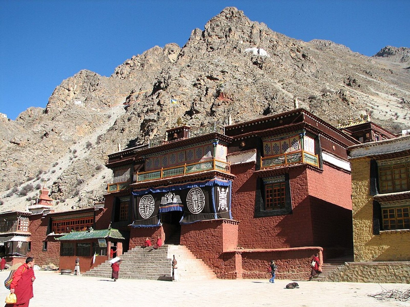 Tsurphu Monastery beneath rocky mountains in Tibet, photographed in 2006.