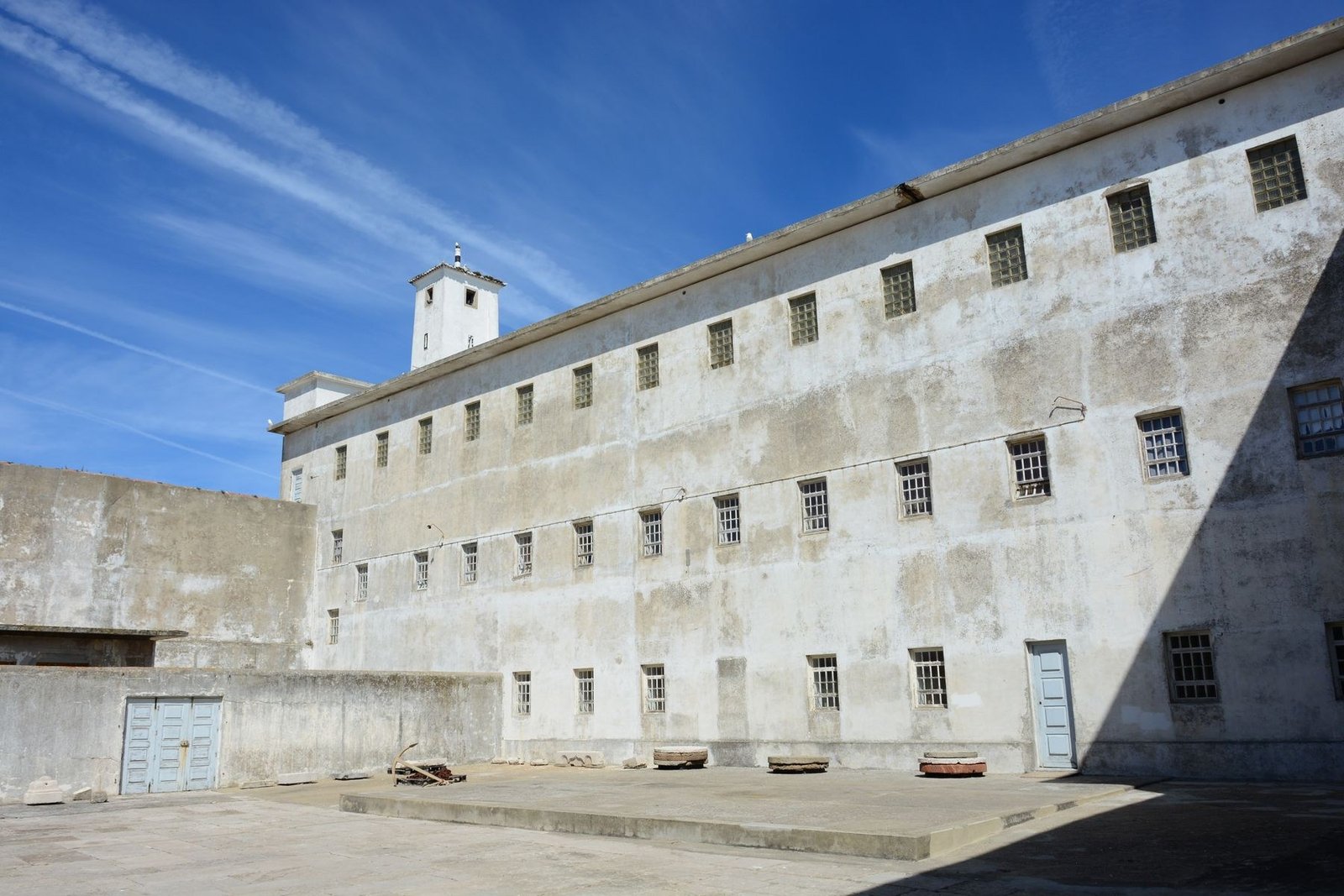 A courtyard, white prison block, and watchtower inside the Fortress of Peniche.
