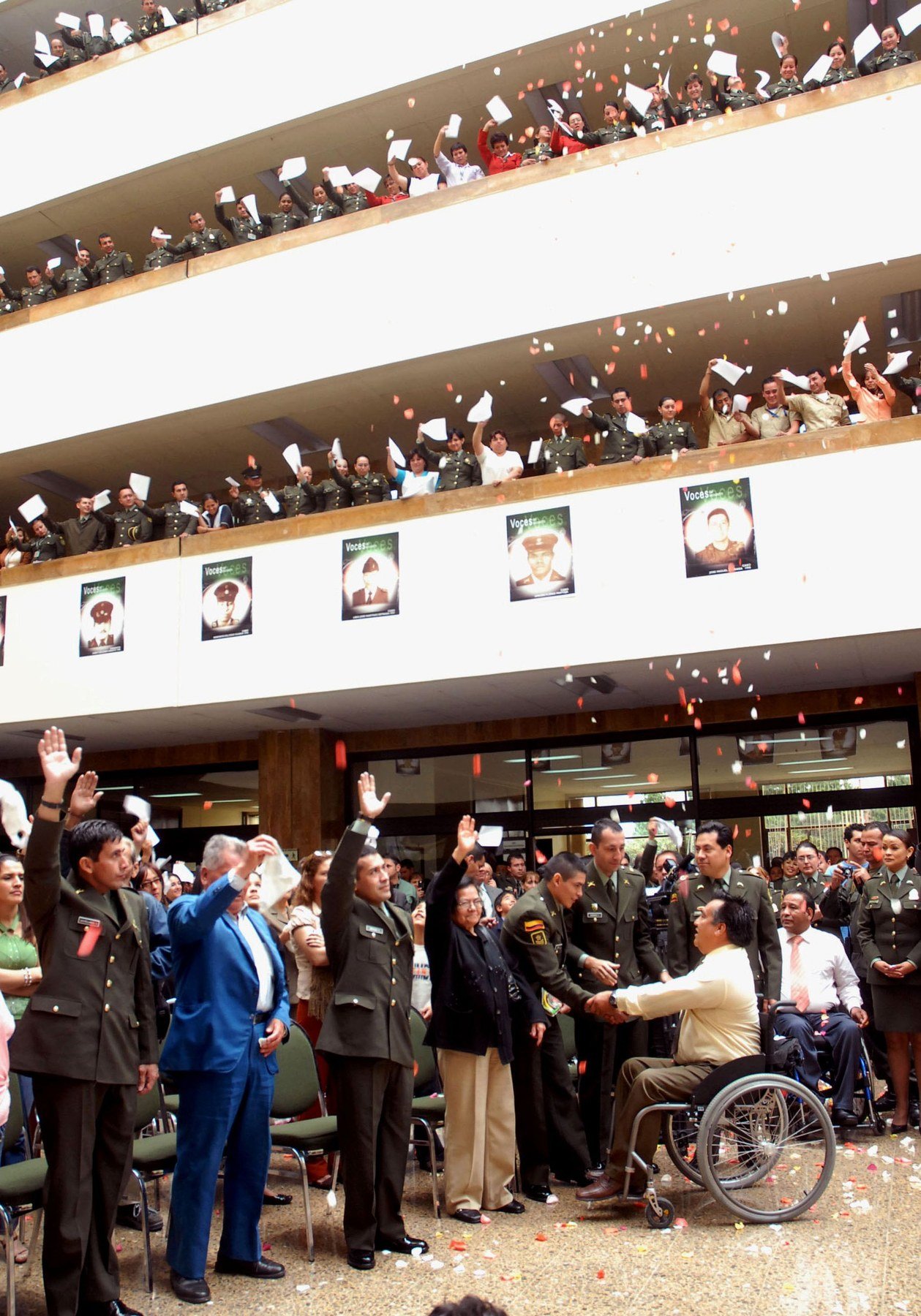 Colombian military and police personnel gathered at a July 2008 tribute after Operation Jaque as rose petals fall through the building.