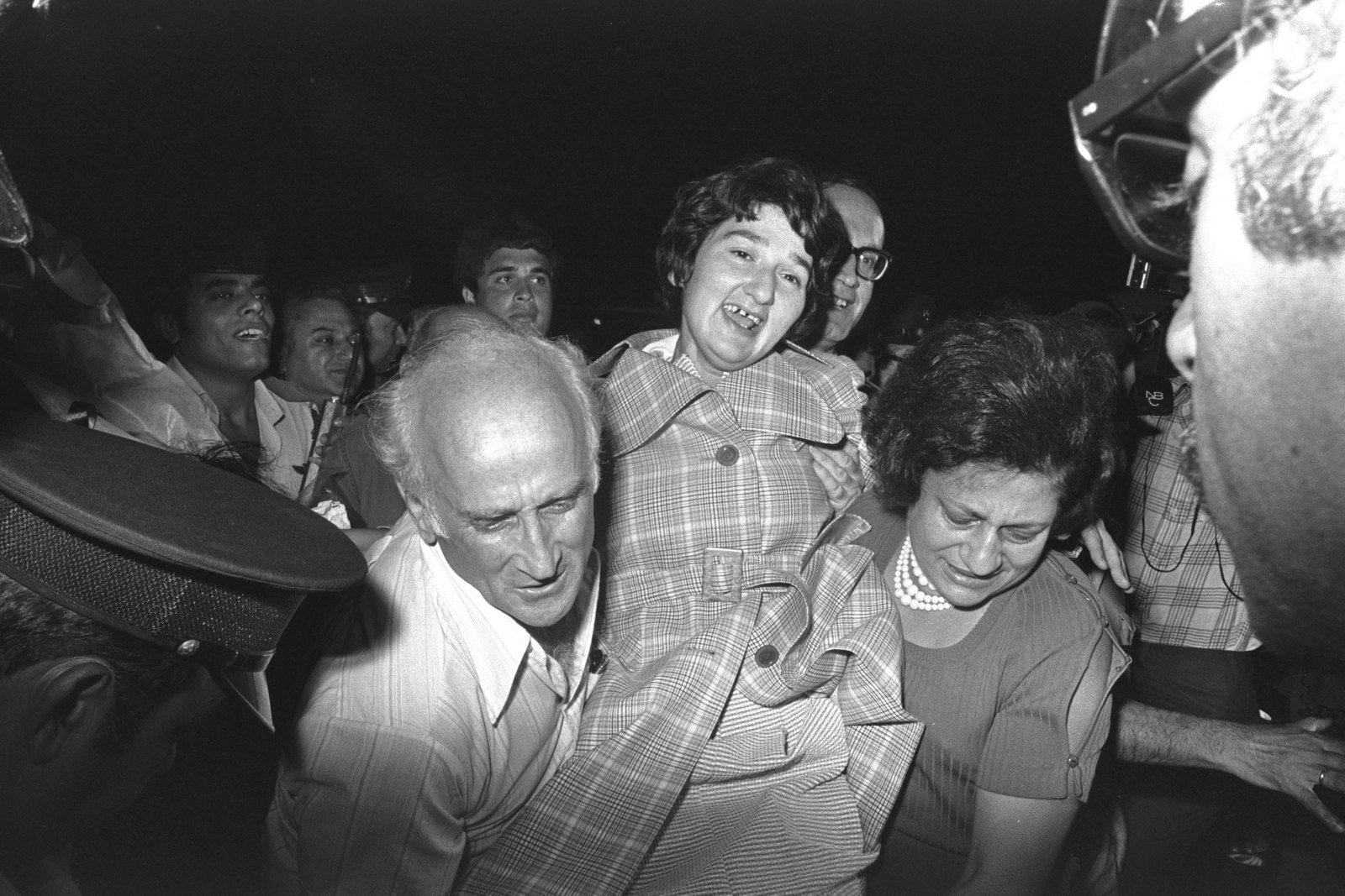 Sylva Zalmanson smiling as relatives carry her through a crowd at Ben-Gurion Airport after her release from Soviet imprisonment in 1974.
