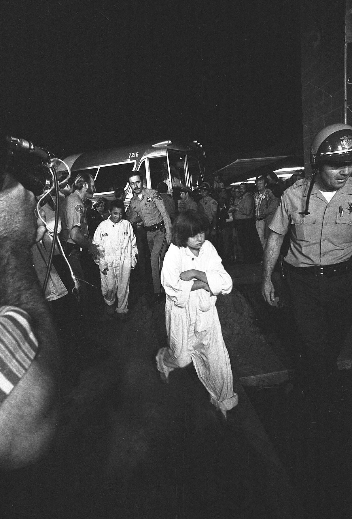 Black-and-white photograph of children from the Chowchilla kidnapping being escorted by sheriff’s deputies after their rescue.