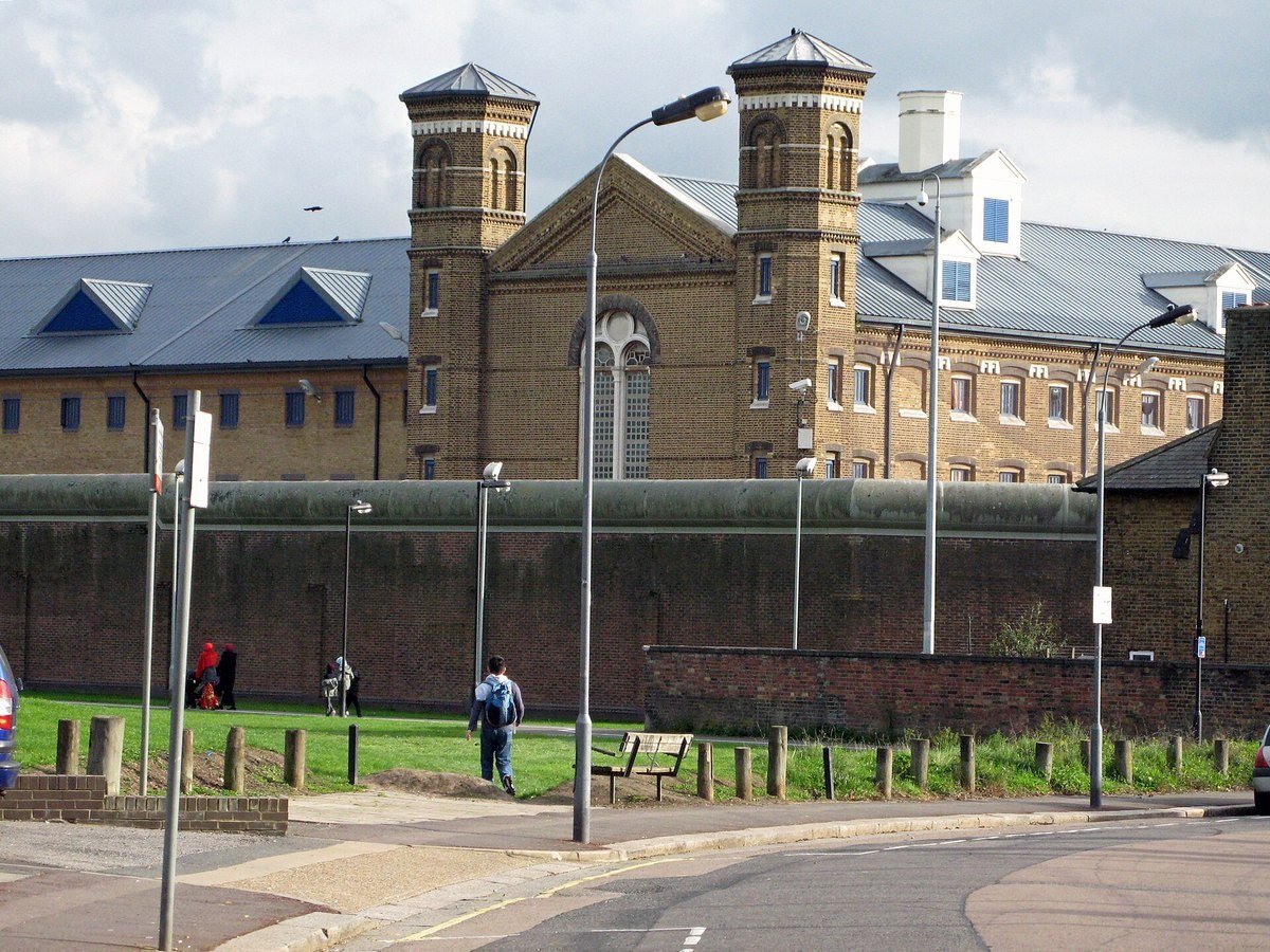 Modern exterior view of HM Prison Wormwood Scrubs in London behind its perimeter walls.