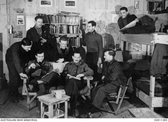 Allied prisoners of war seated in a furnished barrack room at Stalag Luft III around 1943.